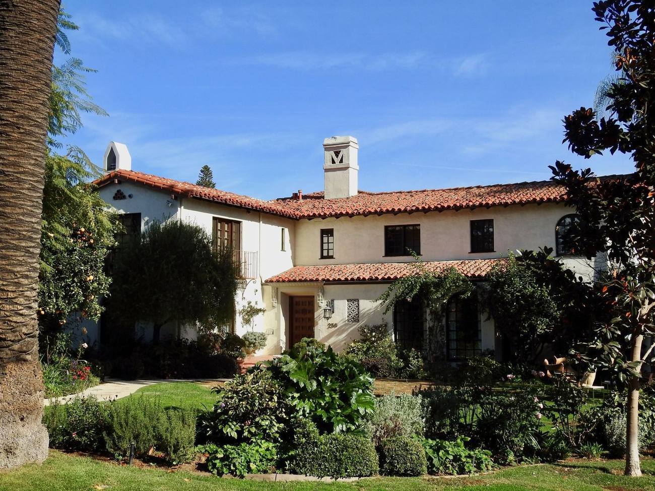 Spanish colonial home behind a deep garden in Brentwood