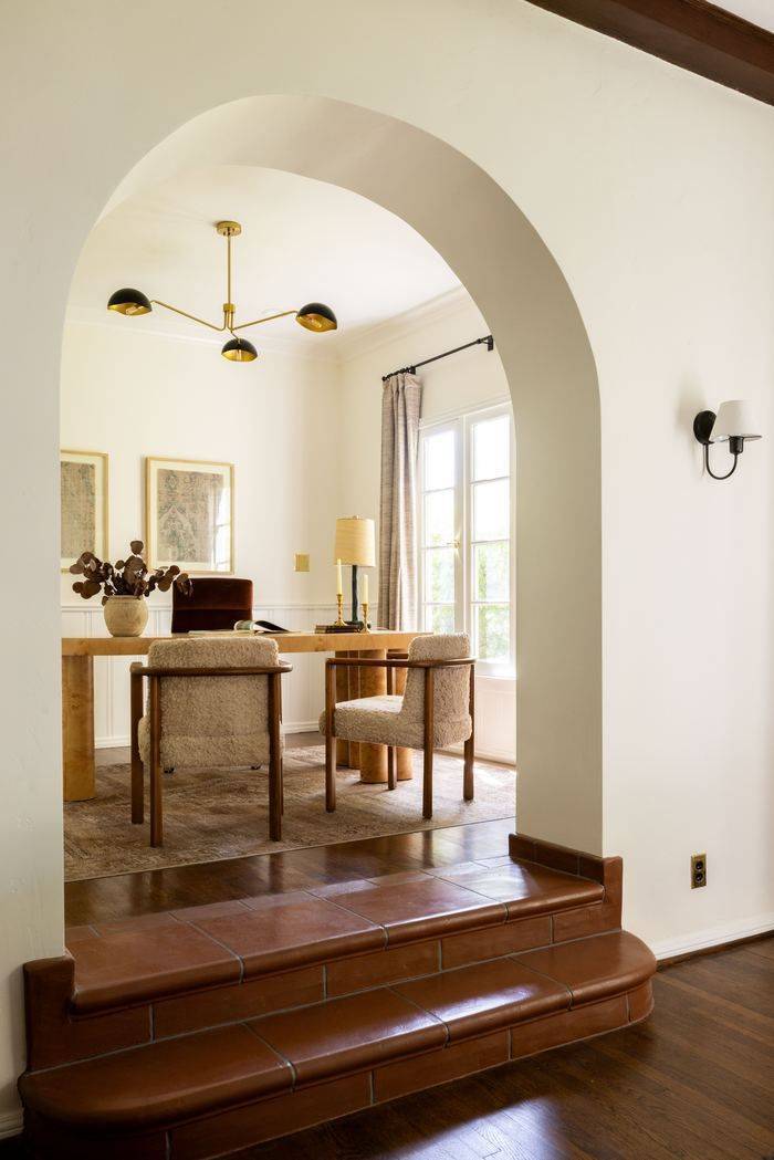 Archway into a wood paneled den, Spanish revival character home
