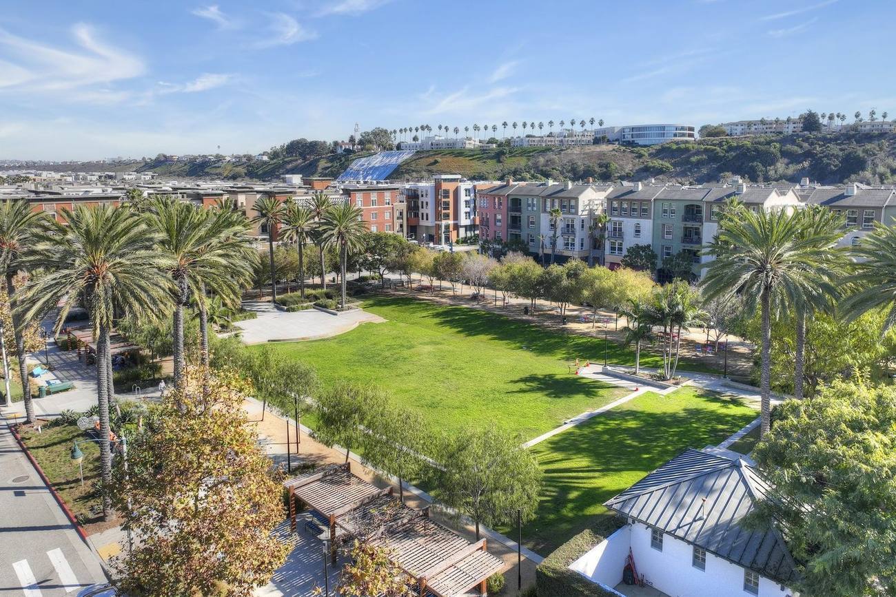 Aerial over the central green at Playa Vista, framed by palms and new residences